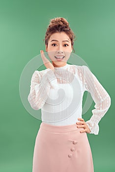 Attrative young Asian woman standing islated over green background