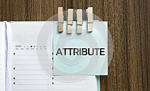 ATTRIBUTE notes paper and a clothes pegs on wooden background