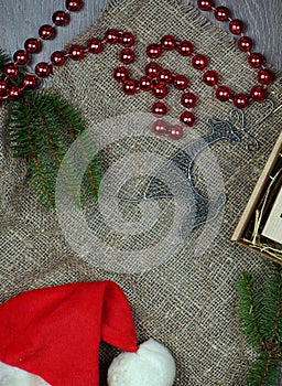 Attributes of christmasnew year in layout on gray background. Spruce branches next to beads and a deer.