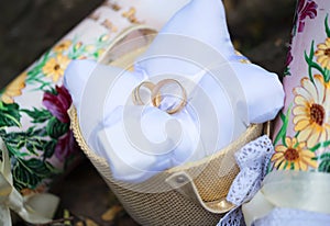 Attributes of the wedding, wedding rings of yellow metal on a white pillow.