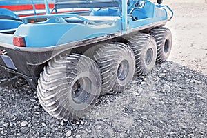 ATV all-terrain vehicle closeup view of aggressive wheels tread standing on sandy soil