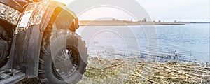 ATV awd quadbike motorcycle pov view near lake or river pond coast with beautiful nature landscape sky background