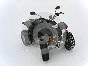 ATV Black All Terrain Vehicle on white snow