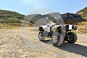 ATV offroad on mountain and sky background.