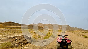 ATV parked on a desolate dirt road in the desert