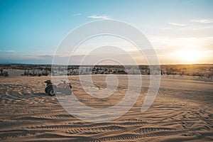 ATV Quad Bike in front of sunrise in the desert. ATV stands in the sand on a sand dune in the desert of Vietnam. MUI ne