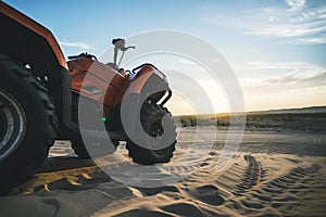 ATV Quad Bike in front of sunrise in the desert. ATV stands in the sand on a sand dune in the desert of Vietnam. MUI ne