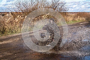 ATV race, dirty road. Uncnown driver in water and mud