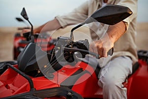 Atv racer in desert, closeup front view on hands