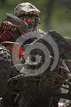 ATV rider covered in mud