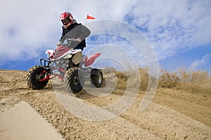 ATV rider spray sand in dunes