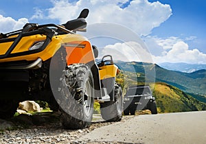 Atv and truck vehicles standing on a mountain landscape road