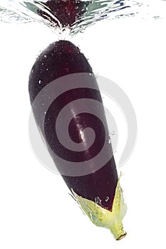 An aubergine falling into the water