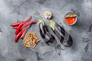 Aubergine penne ingredients eggplant pasta, pepper tomatoe sauce, on grey background top view