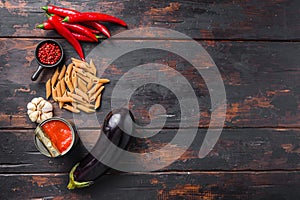 Aubergine penne ingredients eggplant pasta, pepper tomatoe sauce, on old wooden table top view  space for text