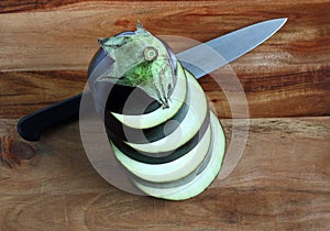 Aubergine, stacked slices with knife
