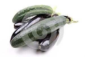 Aubergines, Solanum melongena, a zucchini and a cucumber on white ground