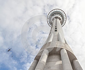Auckland sky tower from below view with model bungee jumping against the sky.