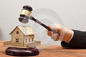 Auction, Real Estate concept. Hand with judge gavel and house model