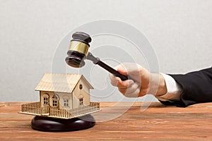 Auction, Real Estate concept. Hand with judge gavel and house model