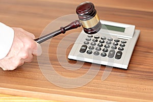 Auction symbol with calculator and gavel on background