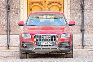 Audi red luxury crossover at the wooden gate door. Russia, Saint-Petersburg. 08. April 2018.