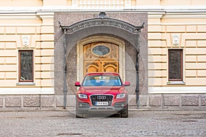 Audi red luxury crossover at the wooden gate door. Russia, Saint-Petersburg. 08. April 2018.