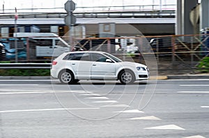 Audi A3 Sportback rides on a street. White 5-door motor car rushes on the road with blurred background