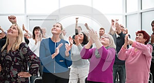 Audience applaud with raised hands in the meeting