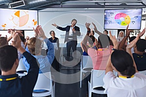 Audience applauding while speaker speaks in a business seminar