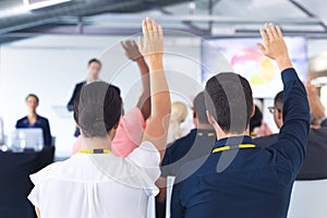 Audience raising their hands in a business conference