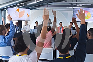 Audience raising their hands in a business conference