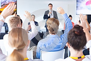 Audience raising their hands in a business conference