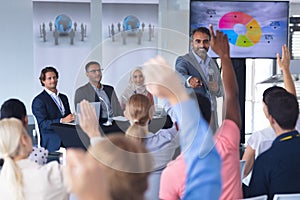 Audience raising their hands in a business conference