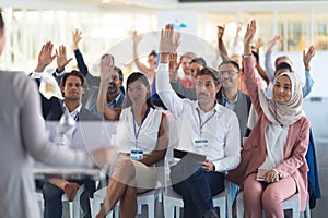 Audience raising their hands in a business conference