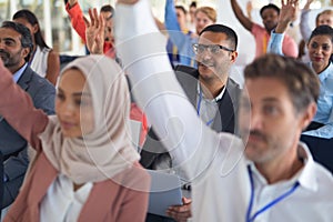 Audience raising their hands in a business conference