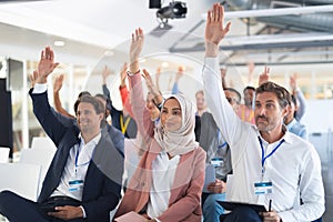 Audience raising their hands in a business conference