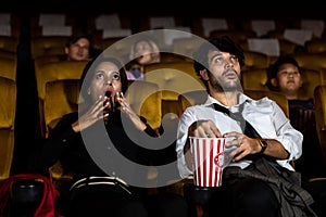 Audience sit in a cinema and watch horror movie