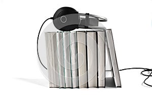 Audio book concept. Big black headphones on the stack of books on white background. Copy space