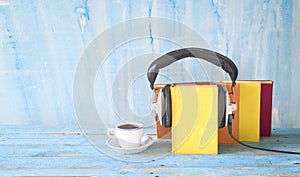 Audio book concept with book, headphones and cup of coffee, panorama format on grungy background, copy space