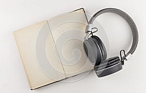 Audio book concept. headphones with book on white background. Listening to book. Modern education. Copyspace