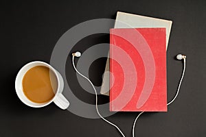 Audio book concept. Headphones, coffee and hard cover book over