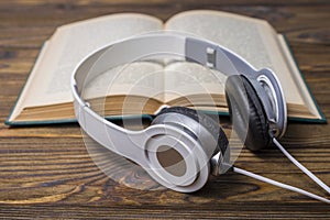 Audio book concept. Headphones and old book