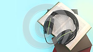 Audio book concept. Headphones, open book and pile of books on turquose background. Listening to book. photo