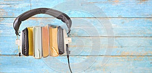 Audio book concept, with row of books, headphones,