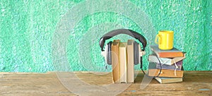 Audio book concept, with stacks of books, headphones and cup of coffee,copy space
