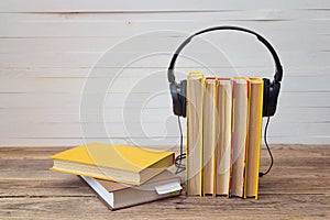 Audio book concept, yellow books and headphones over white background.