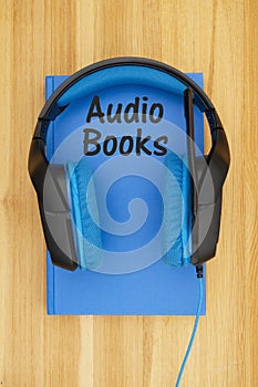 Audio books message with blue and black headset with microphone with a book