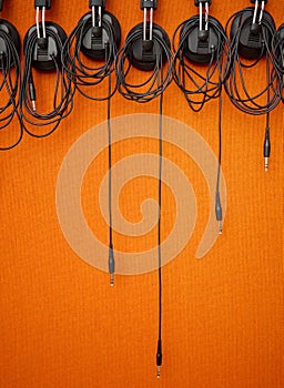 Audio, cables and mockup on an orange wall background in a music studio for recording or sound engineering. Media