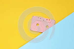 Audio cassette on a pastel-colored paper background. Retro media technology 80s. Music, entertainment. Top view. minimalism trend.